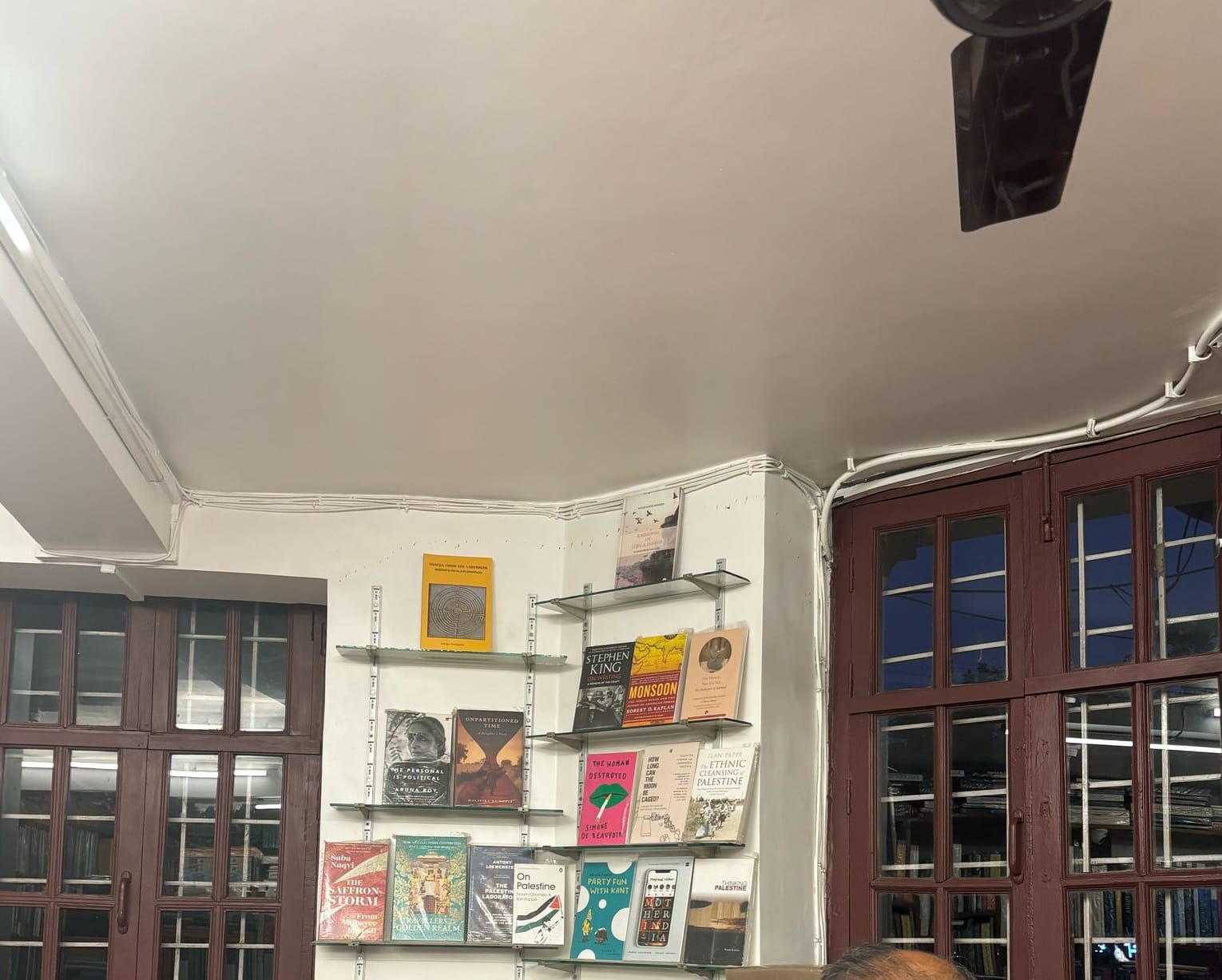Shelves in a bookstore host several books on Palestine and Kashmir, including On Palestine by Noam Chomsky.