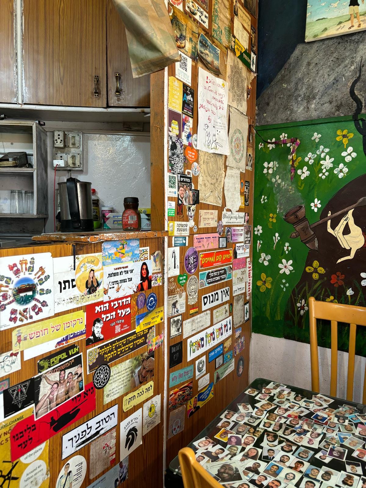 The wall of a restaurant is coated in Hebrew stickers, showing images of soldiers.